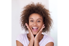 Image Smiling woman with hands on face showing excitement and healthy skin